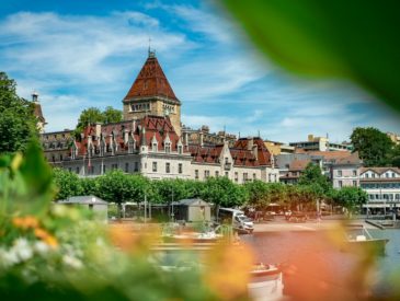 a building with a tower and a body of water in front of it