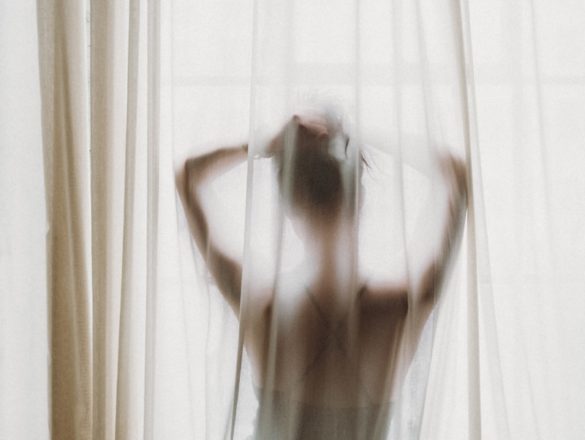 woman in white tank top raising her hands