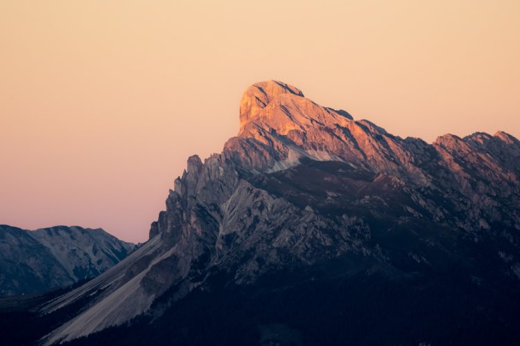 Jagged mountain peak bathed in warm sunset light.
