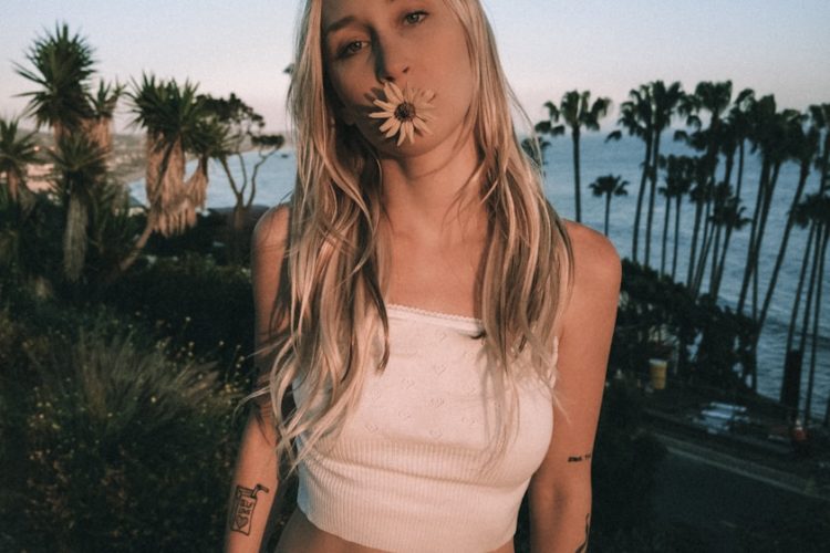 Woman with flower in mouth, palm trees, ocean view