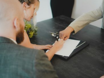 a woman showing a man something on a tablet