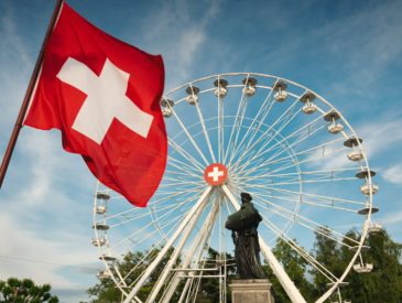 a large ferris wheel sitting next to a statue